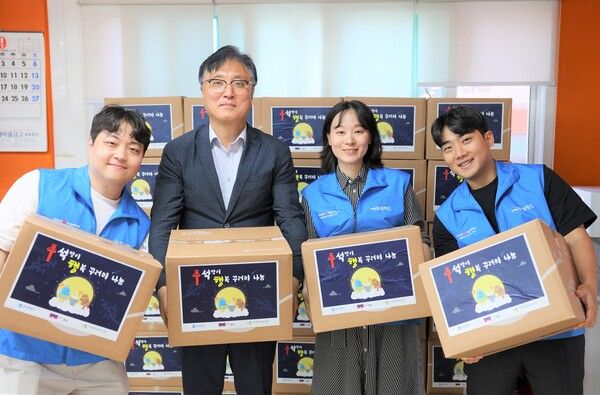 창신2동 남성현 동장(왼쪽 두 번째)과 우리카드 임직원들이 행복 꾸러미 전달 후 기념촬영을 하고 있다.