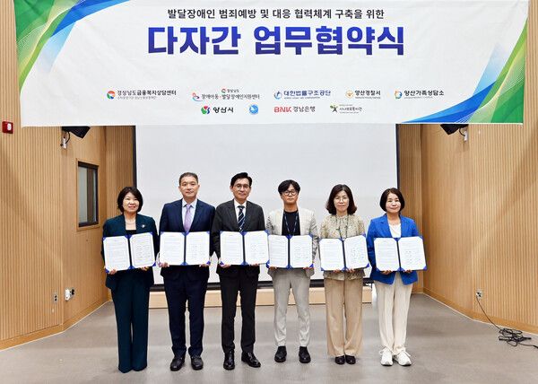 지난 6일 양산시 시나브로복지관에서 BNK경남은행 김경옥 상무(왼쪽 첫 번째)와 참여 기관 관계자 등이 ‘발달장애인 범죄예방 및 대응 협력체계 구축을 위한 다자간 업무협약’을 체결하고 있다. /BNK경남은행