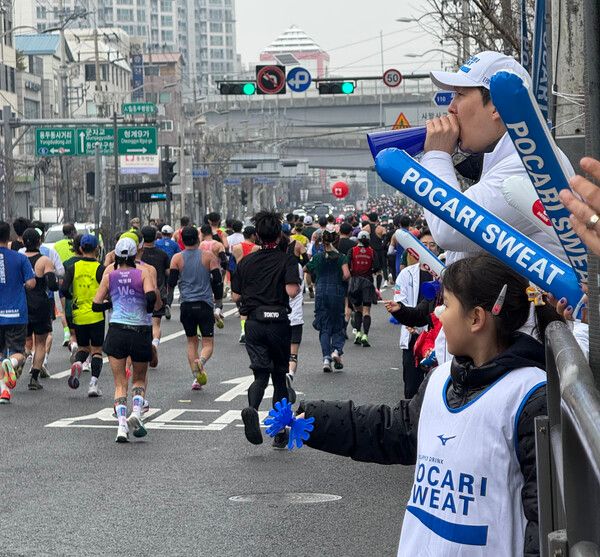 동아오츠카 본사에서 동아오츠카 임직원 및 가족이 2026 서울마라톤 참가자들을 응원하고 있다 / 동아오츠카 제공 (포인트경제)