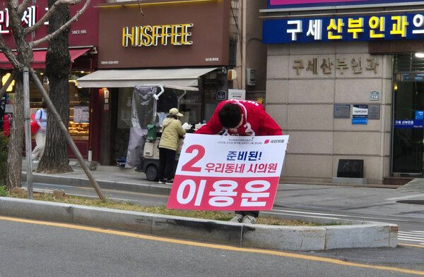 국민의힘 이용운 부산시의원 예비후보가 최근 서구의 한 도로에서 에서 지나가는 행인들과 운전자들을 향해 90도 인사를 하고 있다. /이용운 페북&nbsp;