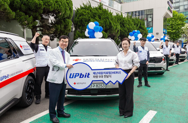 두나무와 대한적십자사가 재난대응의료팀(HERU)&nbsp;차량전달식 개최를 기념해 사진을 촬영하고 있다.&nbsp;사진 앞줄 왼쪽부터 채동완 대한적십자사 서울적십자병원장 겸 의료원장, 이수민 두나무 임팩트비즈니스실 실장. /두나무 제공