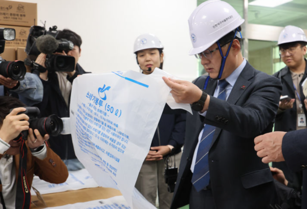 김성환 기후에너지환경부 장관이 3일 오전 종량제봉투를 생산하는 인천 서구의 장애인 직업재활시설을 찾아 재생 50% 혼합의 종량제봉투를 살펴보고 있다. /사진=뉴시스