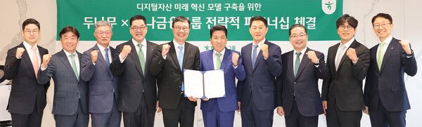 하나금융그룹은 15일 주요 관계사인 하나은행을 통해 국내 최대 가상자산 인프라를 보유한 ‘두나무’에 대한 1조원 규모 지분을 취득하고, 금융과 디지털자산을 연계한 미래혁신모델 구축을 위한 전략적 업무협약을 체결했다. 이날 협약식에 참석한 함영주 하나금융그룹 회장(사진 왼쪽에서 여섯번째)과 김형년 두나무 부회장(사진 왼쪽에서 다섯번째)이 협약서를 들고 양사 관계자들과 함께 기념촬영을 하고 있다.&nbsp;(사진 왼쪽부터 박현중 두나무 총괄이사, 박근영 하나금융티아이 대표이사, 최원석 두나무 부사장, 이은형 하나금융그룹 부회장, 김형년 두나무 부회장, 함영주 하나금융그룹 회장, 오경석 두나무 대표이사, 이호성 하나은행장, 정민석 두나무 부사장, 남호식 하나금융그룹 상무) /하나금융그룹