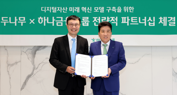 하나금융그룹은 15일 주요 관계사인 하나은행을 통해 국내 최대 가상자산 인프라를 보유한 ‘두나무’에 대한 1조원 규모 지분을 취득하고, 금융과 디지털자산을 연계한 미래혁신모델 구축을 위한 전략적 업무협약을 체결했다. 이날 협약식에 참석한 함영주 하나금융그룹 회장(사진 오른쪽)이 김형년 두나무 부회장(사진 왼쪽)과 함께 협약서를 들고 기념촬영을 하고 있다.&nbsp;/하나금융그룹