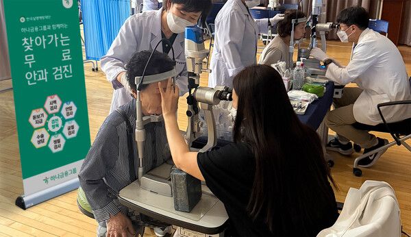 이날 검진에 참석한 어르신께서 의사의 도움을 받아 안과 검진을 받고 있다. /하나금융 제공