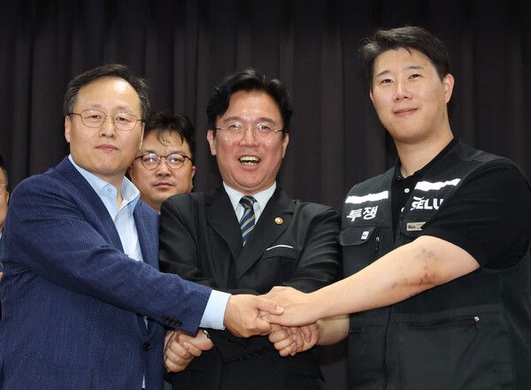 20일 경기 수원시 장안구 경기고용노동청에서 열린 삼성전자 임금협상을 마친 후 여명구 삼성전자 DS(디바이스솔루션·반도체 사업 담당) 피플팀장(왼쪽부터)과 김영훈 고용노동부 장관, 최승호 삼성그룹 초기업노동조합 삼성전자지부 위원장이 잠정 합의한에 서명한 후 손을 맞잡고 파이팅을 외치고 있다. /사진=뉴시스
