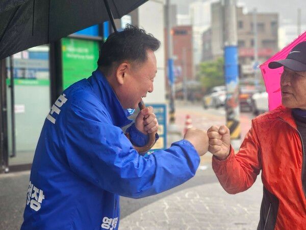 오는 6.3 지방선거에서 부산 영도구청장 탈환을 선언한 더불어민주당 김철훈 후보(왼쪽)가 지역구에서 만난 주민과 친근하게 주먹 악수를 하고 있다. /김철훈 후보 페북