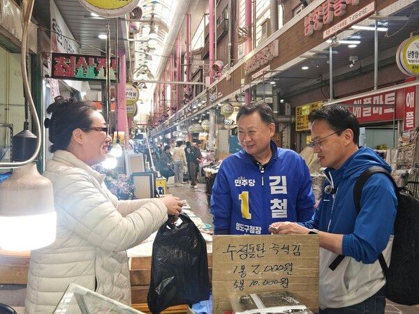 오는 6.3 지방선거에서 부산 영도구청장 탈환을 선언한 더불어민주당 김철훈 후보(가운데)가 부산을 찾은 박주민 국회의원(오른쪽)과 재래시장을 찾아 물건을 구입하며 대화를 나누고 있다. /김철훈 후보 페북