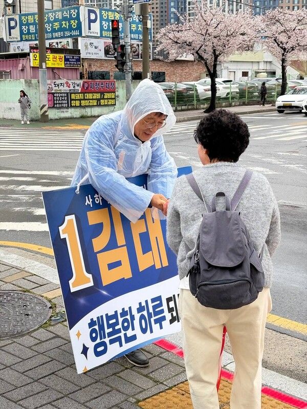 더불어민주당 김태석 부산 사하구청장 후보가 4년의 공백을 깨고 재도전에 나선 가운데 지역구의 도로에서 구민과 인사를 나누고 있다. /김태석 캠프