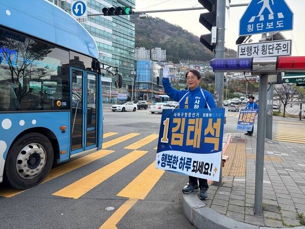 더불어민주당 김태석 부산 사하구청장 후보가 4년의 공백을 깨고 재도전에 나선 가운데 지역구의 도로에서 운전자들과 승객들에게 인사를 하고 있다. /김태석 캠프