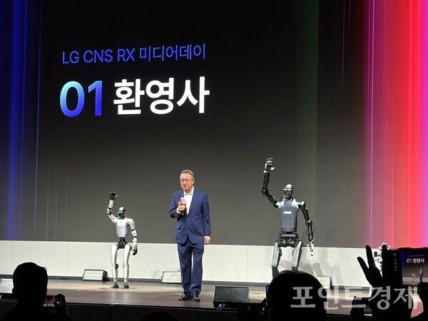 두 종류의 이족보행 로봇과 함께 LG CNS RX 미디어데이 환영사에 나선 현신균 대표의 모습. (포인트경제)