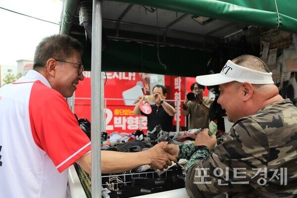 국민의힘 박형준 부산시장 후보가 1일 오후 부산 동구 초량육거리에서 양말을 판매하는 노점 상인과 악수를 나누고 있다. (사진=윤선영) ⓒ포인트경제