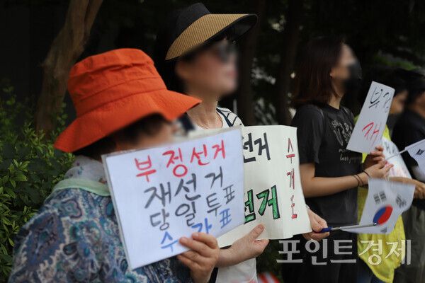 지난 12일 연제구 부산시선관위 앞에 모인 유권자들이 ‘부정선거, 재선거, 당일투표, 수개표’라고 적힌 손피켓을 들고 있다. (사진=윤선영) ⓒ포인트경제