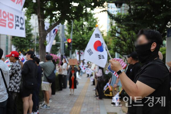 지난 12일 연제구 부산시선관위 앞에서 젊은 층을 비롯한 다양한 연령대의 유권자들이 손태극기를 들고 보도에 서서 조용한 항의를 이어가고 있다. (사진=윤선영) ⓒ포인트경제