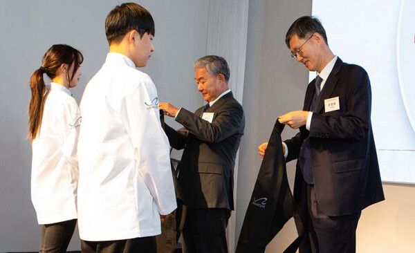 평창 바랑재에서 진행된 바랑재드림키친 입학식에 문형배 전 헌법재판소 재판관과 홍봉성 라이나전성기재단 이사장이 참석해 참가 청년들에게 앞치마를 수여하고 있다 / 사진=라이나생명 (포인트경제)
