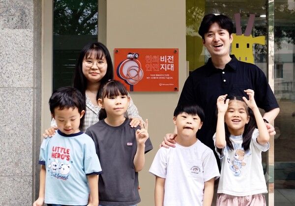 인천 ‘동심원’ 아이들과 직원들이 '비전지대' 현판을 배경으로 기념 촬영을 하고 있다.