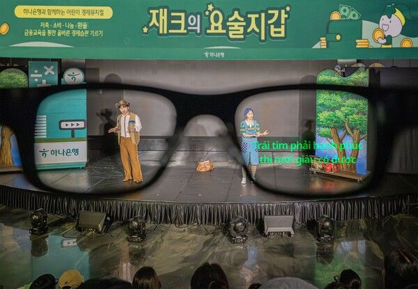 다문화 가족 관람 편의를 위해 제공된 AI 스마트 안경에 '마음이 행복해야 부자가 될 수 있다'는 뮤지컬 대사가 베트남어 자막으로 표시되고 있다. /하나은행