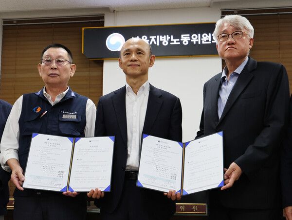 서울 시내버스 노사 협상이 극적으로 타결되어 16일 오전 서울 영등포구 서울지방노동위원회에서 김정환 서울시버스사업조합 이사장(오른쪽부터)과 권병희 서울지방노동위원회 위원장, 박점곤 서울시버스노동조합 위원장이 조정안을 들고 기념촬영을 하고 있다. /뉴시스