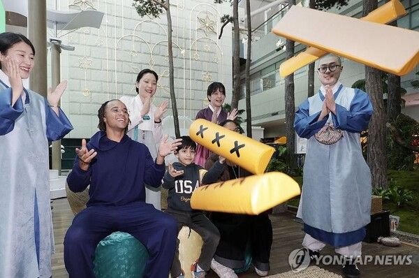 외국인 관광객들이 윷놀이 체험을 하고 있다. 사진=연합뉴스