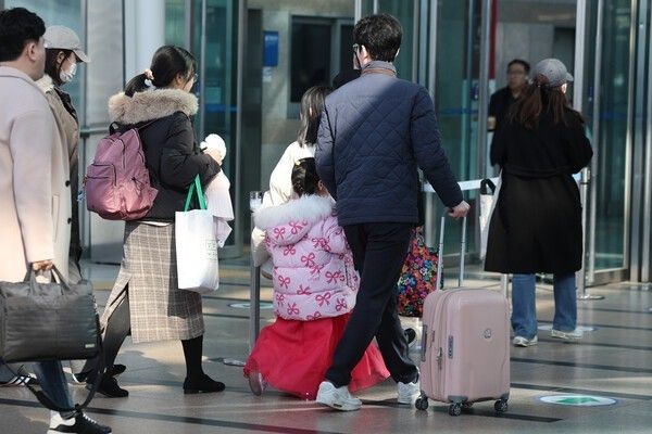 People wearing hanbok while traveling home for the holidays. Photo by Yonhap News .