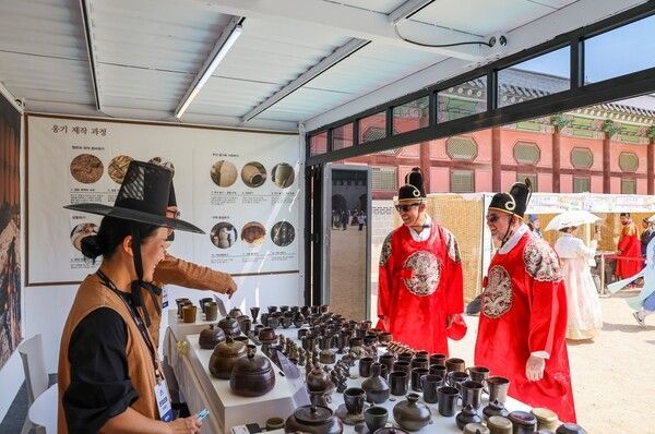 경복궁 K-Heritage마켓 - 곤룡포 입은 외국인 관람객, 옹기 앞에서 활짝2026 봄 궁중문화축전이 열리고 있는 경복궁 K-Heritage 마켓 ‘국가무형유산 옹기장’ 부스에서 곤룡포를 차려입은 외국인 관람객들이 전승자의 설명을 들으며 옹기를 살펴보고 있다. K-Heritage 마켓은 국가무형유산 전승자의 전통 공예품과 조선 왕실 진상품을 만나는 ‘전승자존’, ‘K-Heritage’를 주제로 한 ‘문화상품존’, 국가유산 사업을 알리는 ‘홍보존’으로 구성돼 있다. 사진=국가유산진흥원