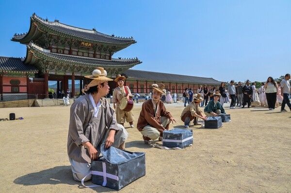 경복궁 K-Heritage마켓_보부상 이벤트 - 흥례문 광장에 펼쳐진 조선의 봇짐… 보부상 행렬 등장2026 봄 궁중문화축전이 한창인 경복궁 흥례문 앞 광장에서 보부상으로 분장한 연희자들이 봇짐을 펼치며 관람객의 시선을 사로잡고 있다. 이 같은 거리 공연은 K-Heritage 마켓의 분위기를 돋우는 깜짝 이벤트로, 조선시대 전국을 누비며 진상품과 생활 물자를 나르던 보부상의 모습을 현대적으로 재현했다. 사진=국가유산진흥원