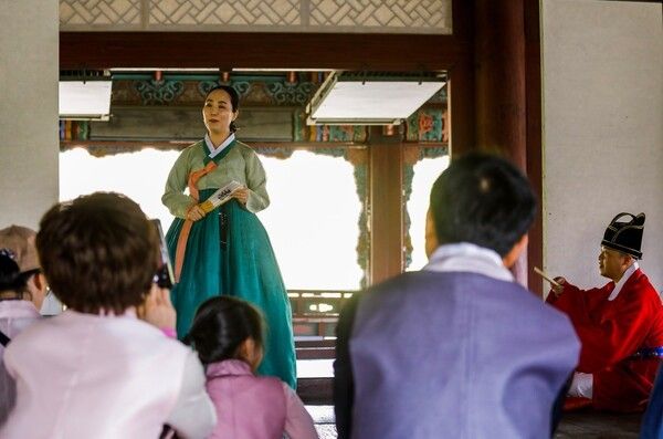 2026 봄 궁중문화축전 신규 프로그램 ‘장악원 악사와 떠나는 경회루 나들이’에 초청된 참가자들이 경복궁 경회루에서 해설자의 안내를 듣고 있다. 이 프로그램은 전통 관악기 ‘풀피리’ 체험과 판소리 배우기('사랑가' 일부 대목), 생황 연주·판소리 감상으로 구성되며, 전문 사진작가의 가족사진 촬영도 함께 제공된다. 장악원 악사와 경회루 나들이 - 풀피리 소리에 미소. 사진=국가유산진흥원
