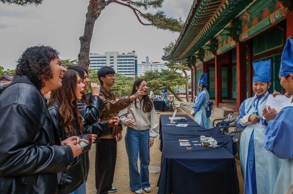 창경궁 궁중놀이방 - 외국인 관람객의 즐거운 도전2026 봄 궁중문화축전이 진행 중인 창경궁 양화당 앞 ‘궁중놀이방’ 부스에서 외국인 관람객들이 자원활동가 ‘궁(宮)이둥이’가 내는 '궁퀴즈'에 답하며 즐거워하고 있다. 사진=국가유산진흥원