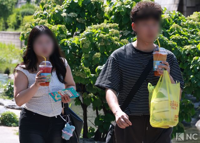 서울 낮 최고 기온이 31도까지 오르며 초여름 날씨를 보인 14일 오후 시민들이 차가운 음료를 들고 청계천 일대를 산책하고 있다. 사진=김규빈 기자