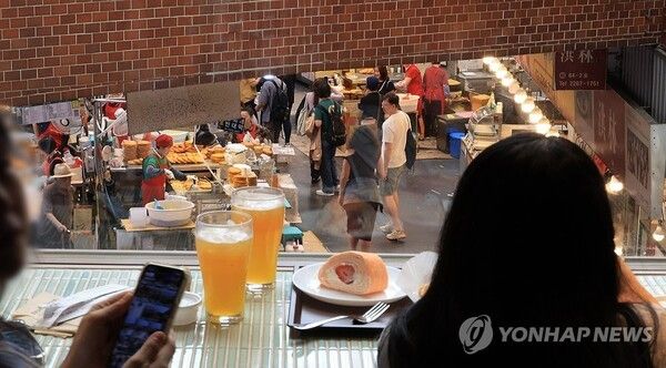 29일 서울 광장시장에 문을 연 스타벅스 스페셜 스토어 '광장마켓점'에서 이용객들이 시장 풍경을 바라보며 차와 디저트를 즐기고 있다. 2025.5.29. 사진=연합뉴스
