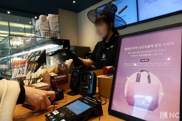 BTS-inspired merchandise tied to the group's signature purple branding is displayed at a major franchise café near Gwanghwamun Square in Seoul. Photo by Kim Gyubin.