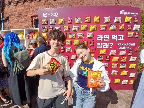 Visitors to a Korean Wave festival in St. Petersburg, Russia, pose with Korean ramen products at a K-food photo wall. Photo courtesy of aT