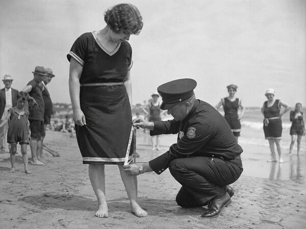 보수적인 윤리관이 지배하던 1920년대 해변. 제복을 입은 경찰관이 무릎까지 내려오는 여성의 수영복 치마 길이를 줄자로 깐깐하게 단속하고 있다. 사진=AI 생성 이미지