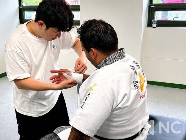 A sports-care specialist checks the shoulder and arm condition of an overseas athlete at a conditioning booth during the championship. Photo courtesy of News Culture DB
