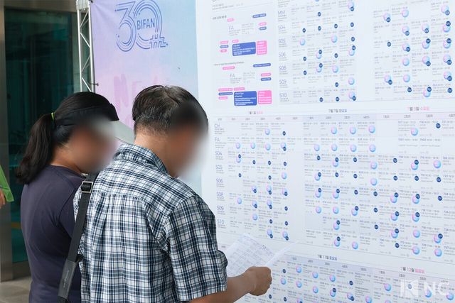 '제30회 부천국제영화제' 상영표를 보고 있는 시민들. 사진=김규빈 기자