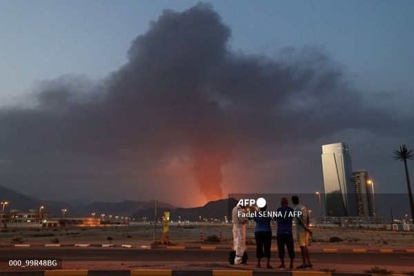 3일 푸자이라 산업단지에서 발생한 폭발 후 치솟는 검은 연기 기둥을 외국인 노동자들이 바라보고 있다. 국제뉴스/AFP통신