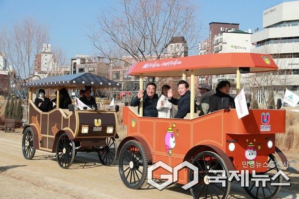 (사진제공=울산시) 14일 태화강 국가정원에서 열린 시승회에 참석한 김두겸 울산시장과 임현철 울산시 대변인이 어린이, 연인 커플과 함께 울산마차를 타고 안전 및 불편사항 등을 점검하고 있다.
