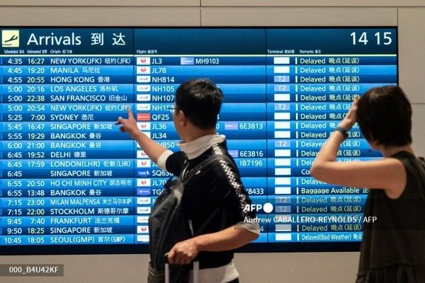 도쿄 하네다 공항 국제선 터미널에서 도착 항공편 안내판을 보고 있는 승객들(위 사진은 기사 내용과 무관함).&nbsp;사진제공/AFP통신