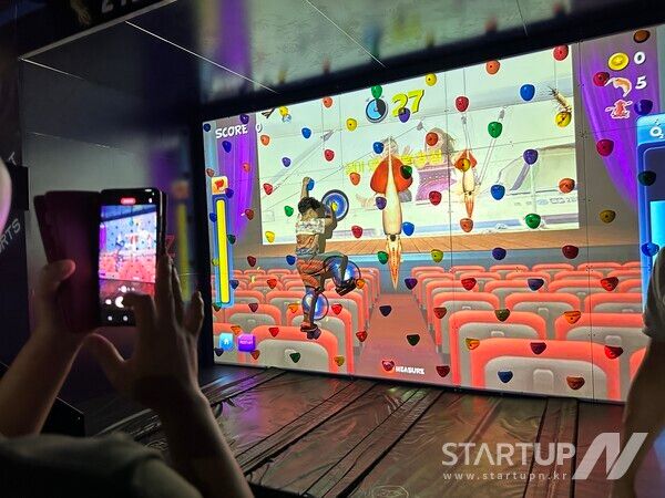 울릉군 저동항에서 열린 제21회 울릉도 오징어 축제 현장에 설치된AR클라이밍 부스에서AR오징어 잡기 체험을 하고 있다. (사진 제공=㈜아스포즈)
