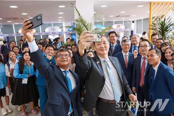 14일 오전(현지시각) 캄보디아 수도 프놈펜의 왕립프놈펜대학교에서 열린 국립창업보육센터(NICC) 개소식에서 장원삼 코이카 이사장(맨 앞줄 오른쪽)과 항 추온 나론 캄보디아 교육부총리(맨 앞줄 왼쪽)가 캄보디아 국립창업보육센터가 육성한 스타트업들의 부스를 시찰한 후 청년 기업가 및 대학생들의 단체사진 촬영 요청에 응하고 있다