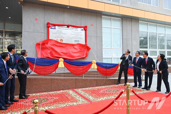 14일 오전(현지시각) 캄보디아 수도 프놈펜의 왕립프놈펜대학교에서 열린 국립창업보육센터(NICC) 개소식에 참석한 내외빈들이 현판을 제막하고 있다. 왼쪽부터 찌읏 찌을리 왕립프놈펜대학교 총장, 산 바타나 왕립프놈펜대학교 이사장, 항 추온 나론 캄보디아 교육부총리, 장원삼 코이카 이사장, 안완기 한국생산성본부 회장, 박정욱 주캄보디아 대한민국 대사, 최문정 코이카 캄보디아 사무소장