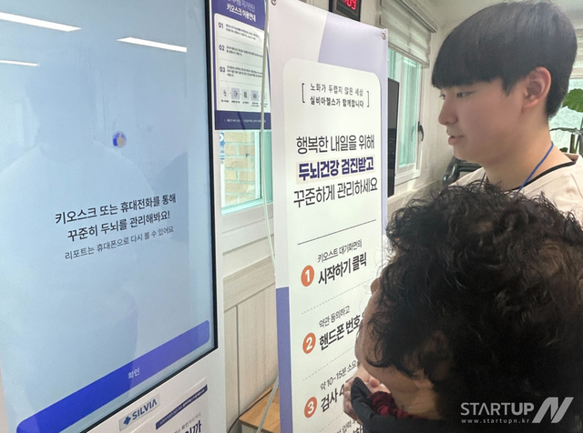 강원 주민에 인지검사 키오스크를 설명 중인 실비아헬스 직원