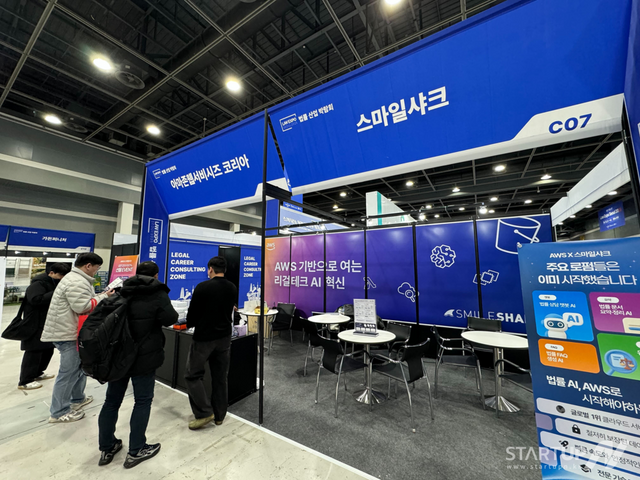 대한민국 법률산업 박람회 2025 스마일샤크 × AWS 공동 부스에서 스마일샤크 직원이 방문객에게 AI 도입 서비스를 소개하고 있다(사진=스마일샤크)