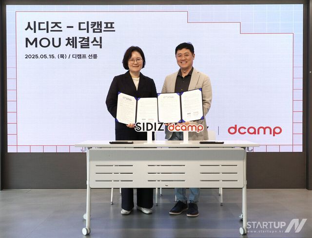 왼쪽부터 시디즈 김태은 대표이사와 디캠프 박영훈 대표이사가 협약서를 들어 보이고 있다.