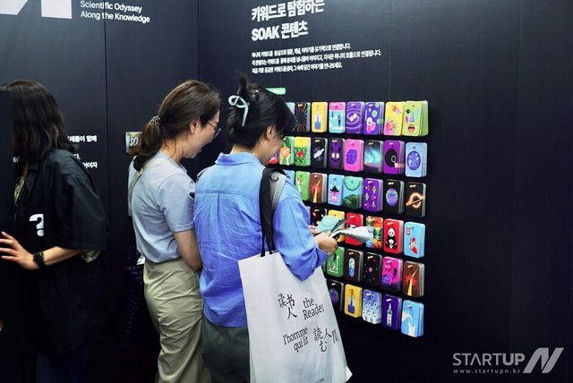 키워드 카드를 통해 SOAK의 주요 콘텐츠를 보고 있는 관람객들 모습