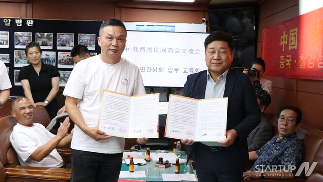 왼쪽부터 타이저우시 유아산업상회 홍리민 회장, 남대문시장상인회 문남엽 회장이 업무협약서를 서명 후 기념촬영을 하고 있는 모습(사진=유인춘 기자)