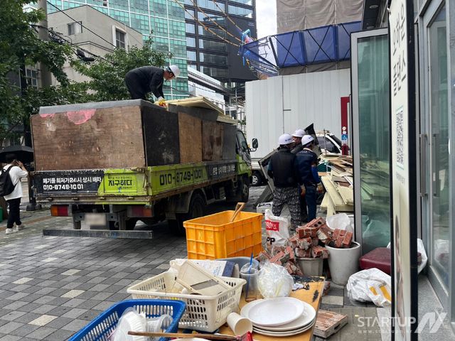 매장에서 나온 철거 폐기물을 인부들이 차량에 상차하고 있다.