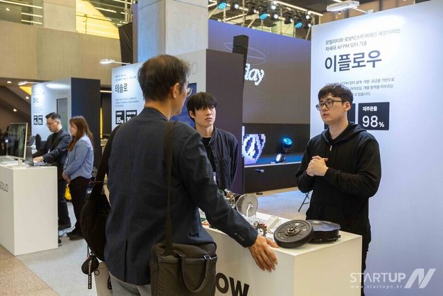 이플로우 부스에서 차세대 모터 기술을 전시하며 방문객과 기술 설명을 나누고 있다.