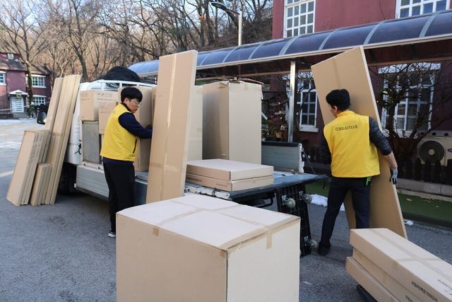 ©AP신문(AP뉴스)/ 이미지 제공 = 신세계까사 ▲신세계까사의 까사미아 배송 기사들이 서울시 중구 사회복지법인 ‘남산원’에서 가구를 옮기고 있다. 신세계까사는 매년 초록우산어린이재단 및 지차체 협업을 통해 ‘희망드림 가구 지원’ 캠페인을 전개, 소외계층 아동들을 위한 가구를 기부한다.