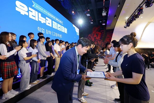 ©AP신문(AP뉴스)/ 이미지 제공 = 우리금융지주 ▲우리다문화장학재단은 서울 중구 소재 우리은행 본점에서 다문화학생 장학금 전달식인 ‘2024년 우리누리 웰컴데이’를 개최했다. 이날 참석한 선배 장학생들이 후배 장학생에게 장학증서를 수여하고 있다.